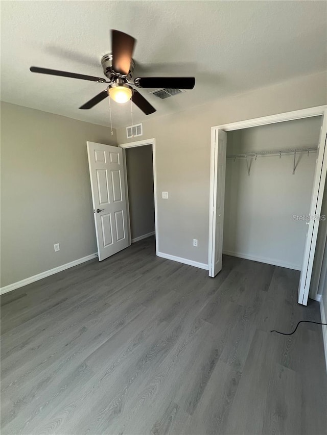 unfurnished bedroom featuring hardwood / wood-style floors, a textured ceiling, a closet, and ceiling fan