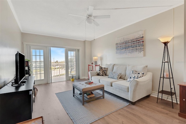 living room with hardwood / wood-style flooring, crown molding, and ceiling fan