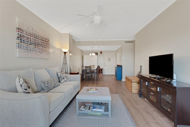 living room with ceiling fan, ornamental molding, and light hardwood / wood-style flooring