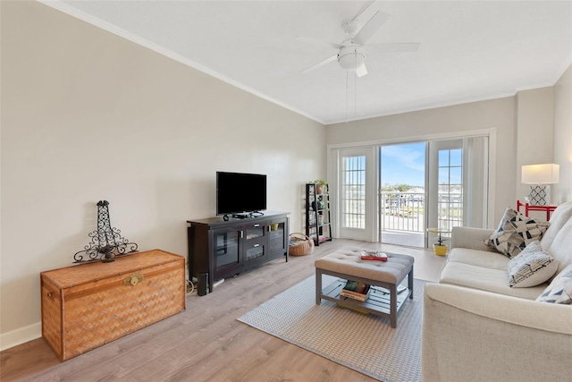 living room featuring crown molding, light hardwood / wood-style flooring, and ceiling fan