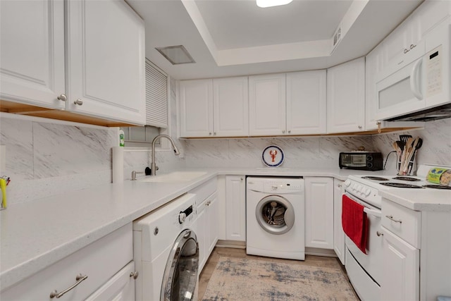 clothes washing area with washer / clothes dryer, sink, and light hardwood / wood-style flooring