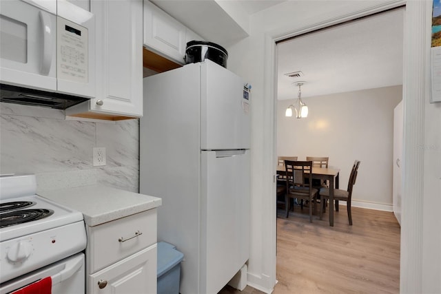 kitchen featuring white cabinetry, tasteful backsplash, light wood-type flooring, pendant lighting, and white appliances