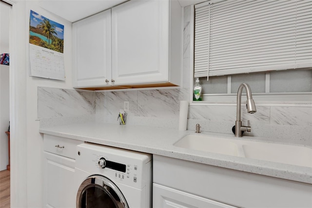 laundry area featuring cabinets, washer / clothes dryer, and sink