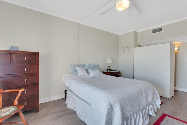 bedroom featuring crown molding, light hardwood / wood-style floors, and ceiling fan