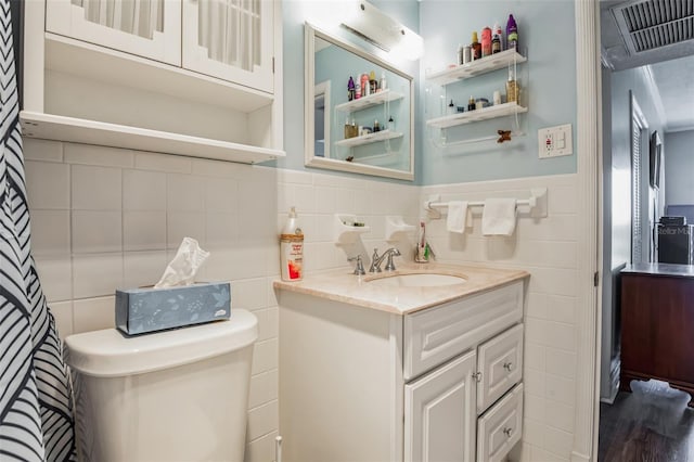 bathroom featuring tile walls, vanity, and toilet