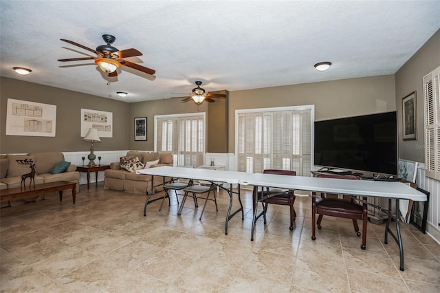 dining space featuring ceiling fan and a textured ceiling