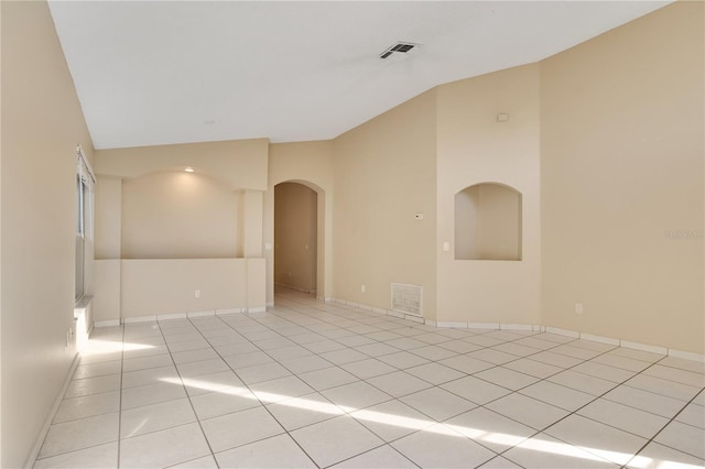 tiled spare room with lofted ceiling