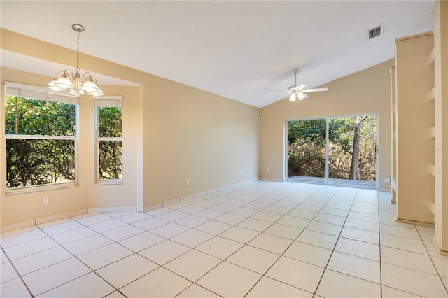 tiled empty room featuring lofted ceiling, ceiling fan with notable chandelier, and a textured ceiling