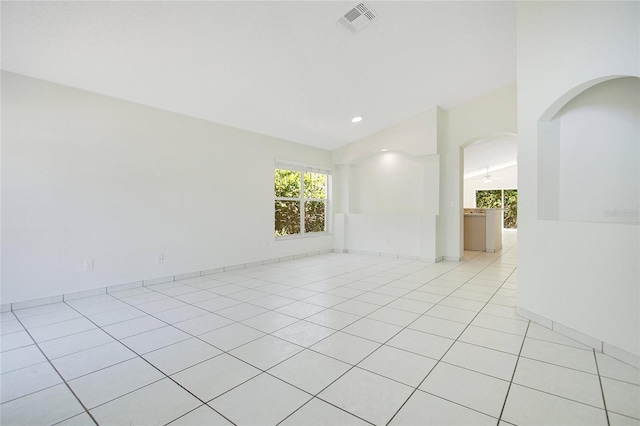 unfurnished room with visible vents, arched walkways, recessed lighting, light tile patterned flooring, and lofted ceiling