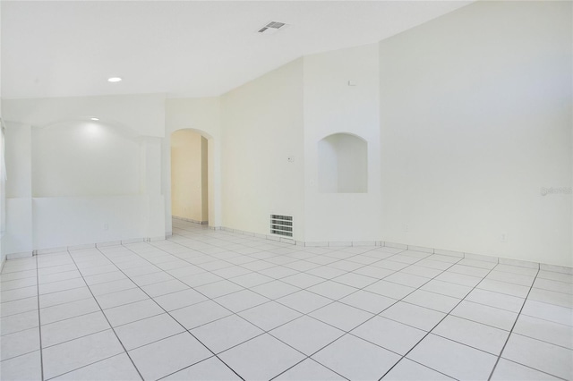 empty room with visible vents, recessed lighting, and arched walkways