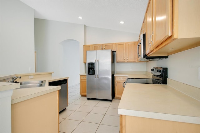 kitchen featuring a sink, light countertops, appliances with stainless steel finishes, and arched walkways