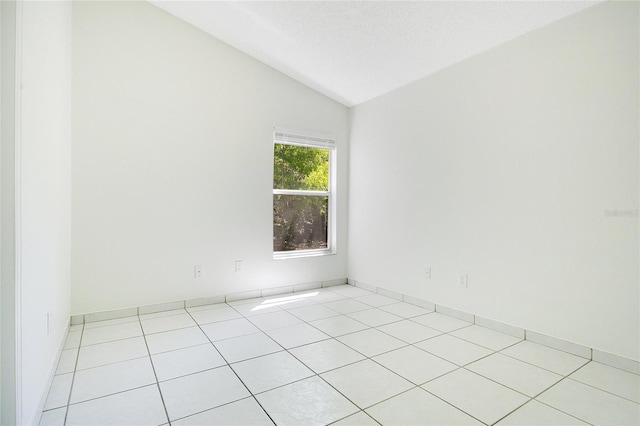 tiled spare room with lofted ceiling