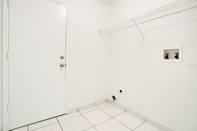 laundry area with laundry area, hookup for an electric dryer, hookup for a washing machine, and light tile patterned floors