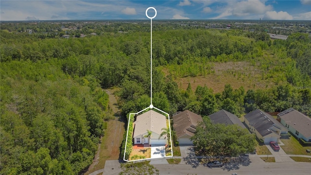 birds eye view of property featuring a forest view