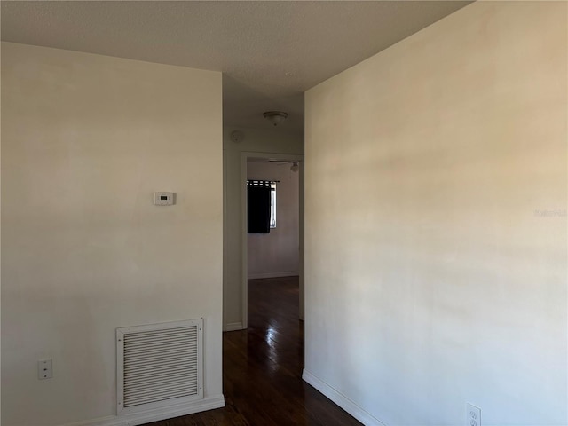 hall featuring dark hardwood / wood-style floors and a textured ceiling