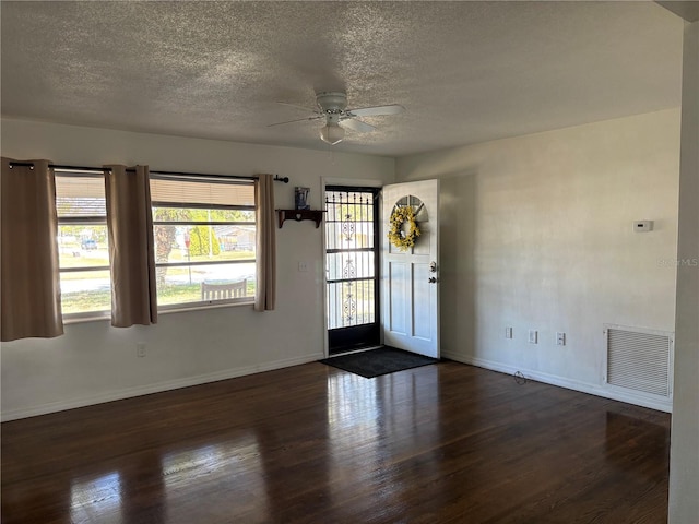 interior space featuring dark hardwood / wood-style flooring, ceiling fan, and a textured ceiling