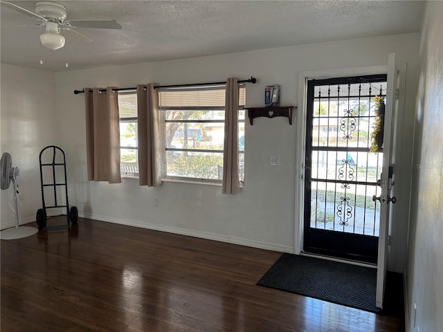 foyer featuring dark hardwood / wood-style flooring, ceiling fan, a textured ceiling, and a healthy amount of sunlight