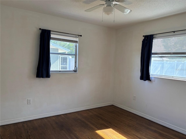 empty room featuring ceiling fan, dark hardwood / wood-style floors, and a textured ceiling