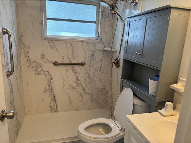 bathroom featuring tiled shower, vanity, and toilet