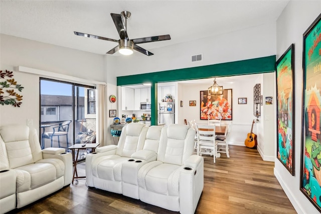 living room featuring ceiling fan with notable chandelier and dark hardwood / wood-style floors