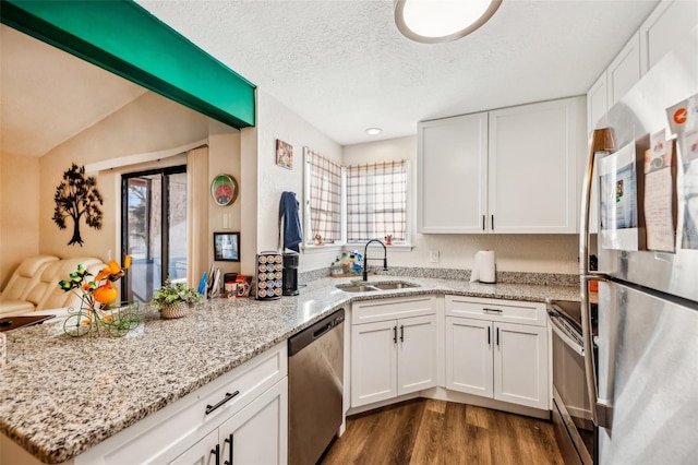 kitchen featuring sink, kitchen peninsula, white cabinets, and appliances with stainless steel finishes