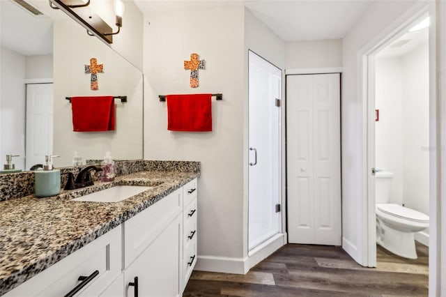 bathroom featuring vanity, hardwood / wood-style floors, toilet, and walk in shower