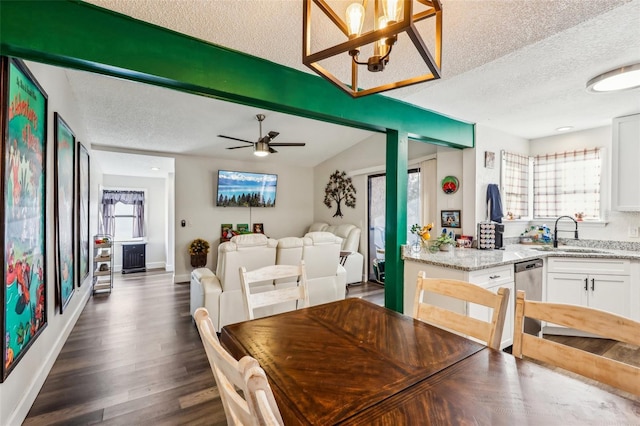 dining space featuring a healthy amount of sunlight, sink, dark wood-type flooring, and a textured ceiling