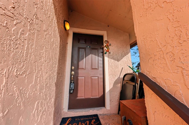 entrance to property featuring stucco siding