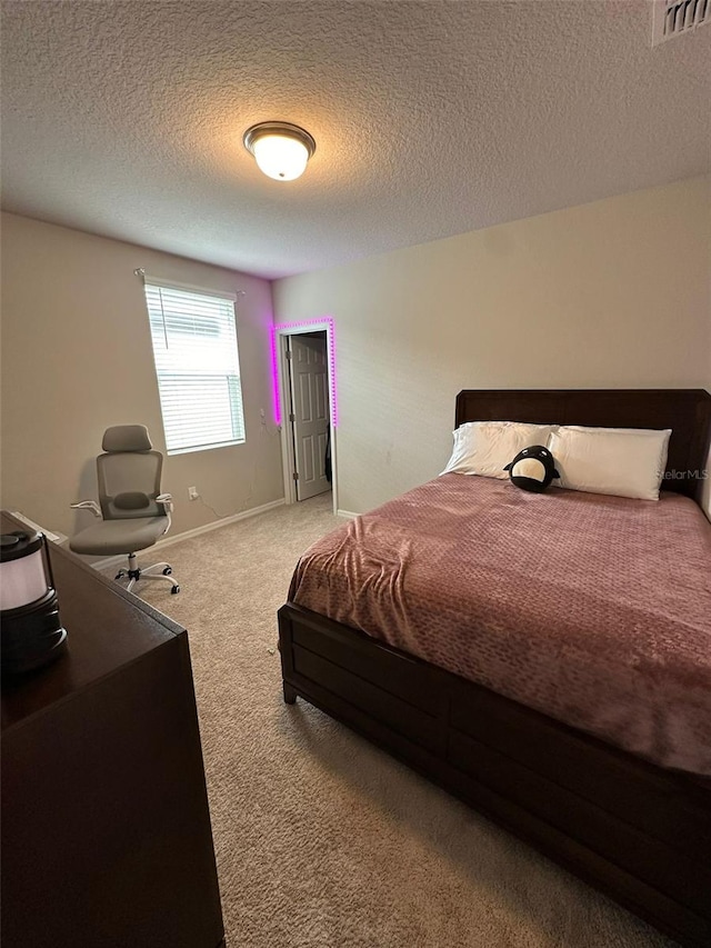 carpeted bedroom with a textured ceiling, a closet, visible vents, and baseboards