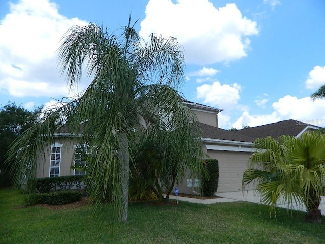 view of side of property featuring a yard and a garage