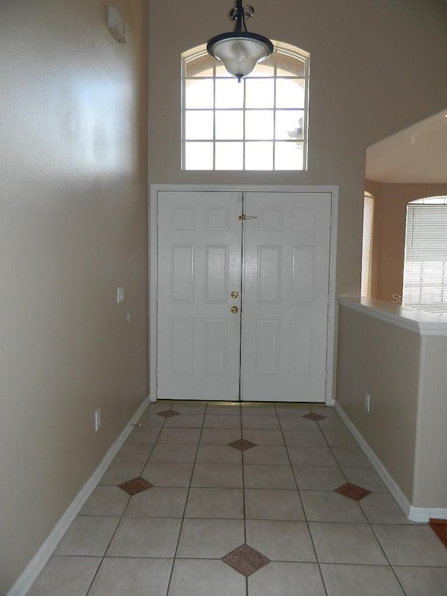 entryway featuring a towering ceiling and tile patterned floors