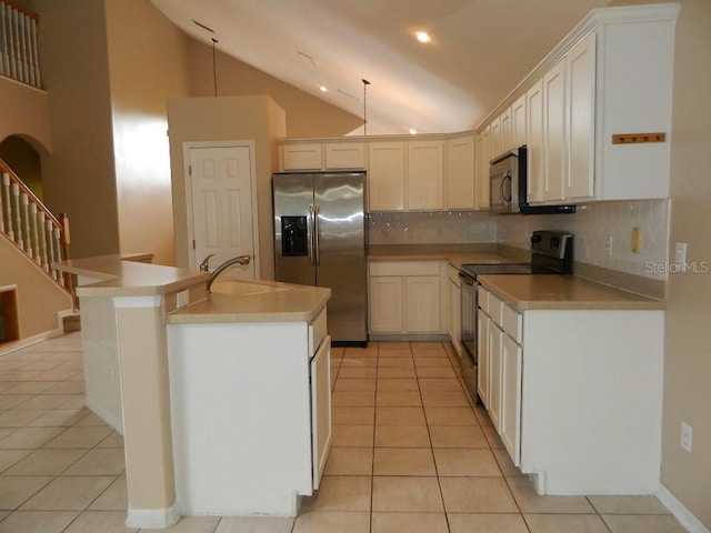 kitchen with appliances with stainless steel finishes, sink, light tile patterned floors, and white cabinets