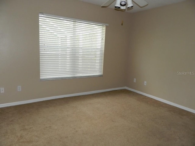 carpeted spare room with ceiling fan