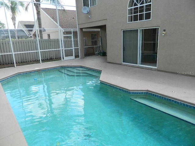 view of swimming pool featuring a lanai and a patio