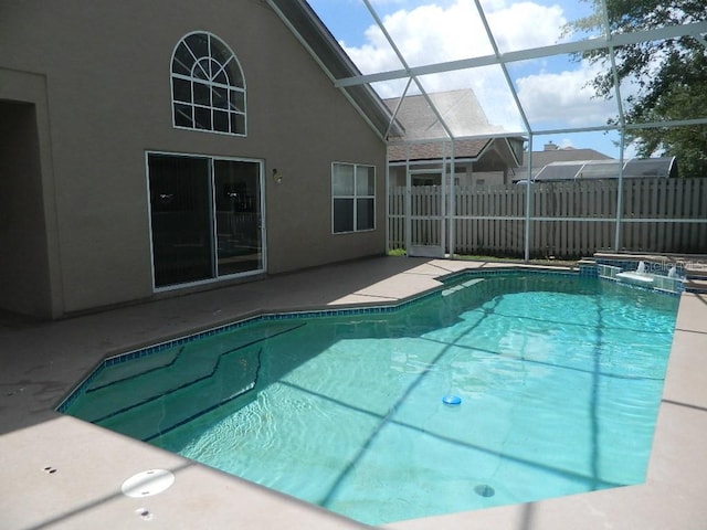 view of pool with a patio and glass enclosure