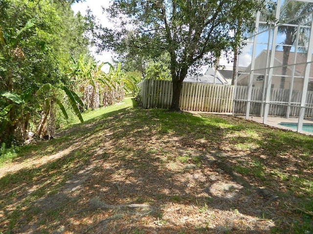 view of yard with a lanai and a fenced in pool