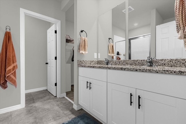 bathroom featuring vanity, tile patterned flooring, and a shower with door