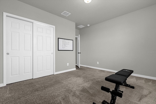 workout area featuring carpet floors and a textured ceiling