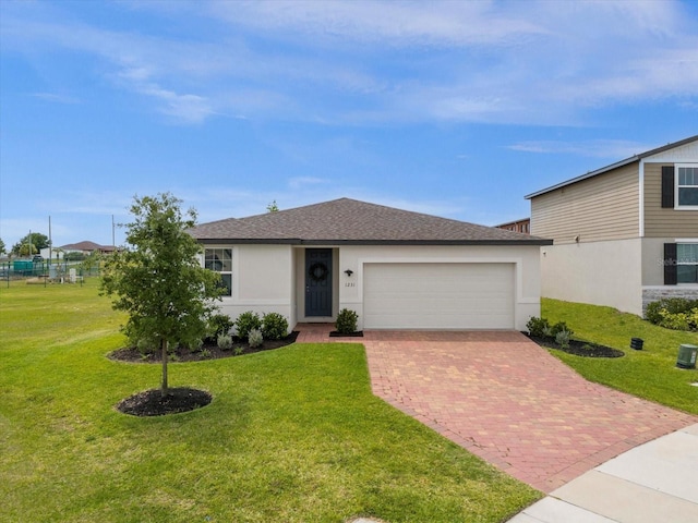 ranch-style house featuring a garage and a front lawn