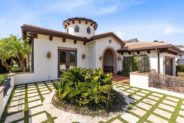 mediterranean / spanish-style home with french doors and a patio area