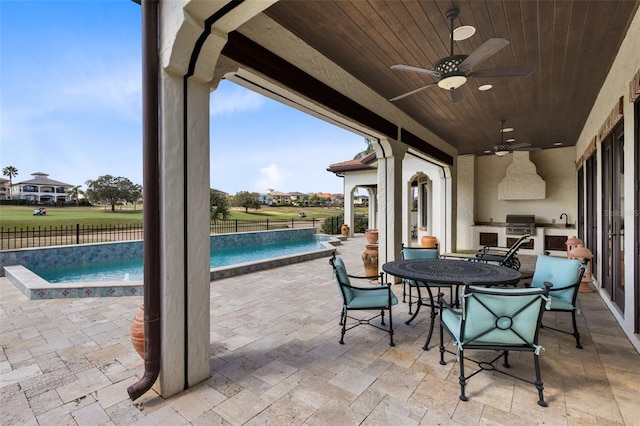 view of patio / terrace featuring sink, ceiling fan, a grill, a pool with hot tub, and an outdoor kitchen