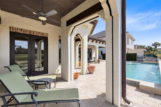 view of patio / terrace featuring pool water feature, ceiling fan, and french doors