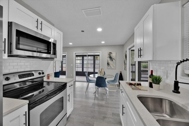 kitchen featuring white cabinetry, sink, a wealth of natural light, and stainless steel appliances