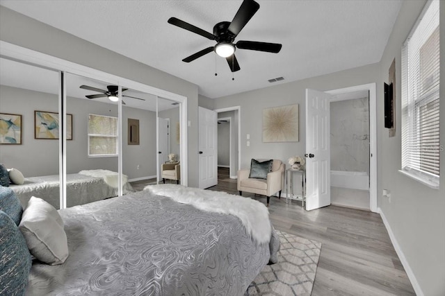 bedroom with ceiling fan, light hardwood / wood-style floors, and a closet