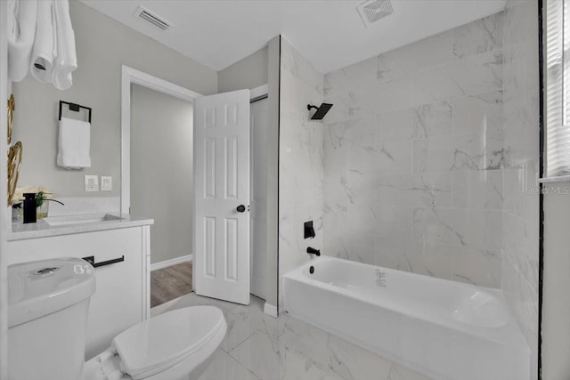 full bathroom featuring tiled shower / bath, vanity, and toilet