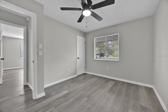 unfurnished room featuring ceiling fan, hardwood / wood-style floors, and a textured ceiling