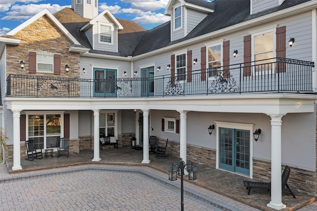 rear view of property with a balcony and a patio area