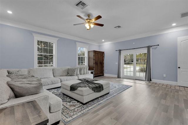 unfurnished living room featuring ornamental molding, a wealth of natural light, and light hardwood / wood-style floors