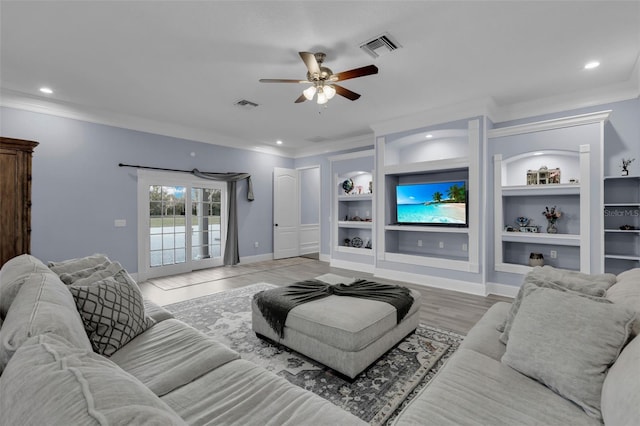 living room featuring ornamental molding, light wood-type flooring, ceiling fan, and built in shelves