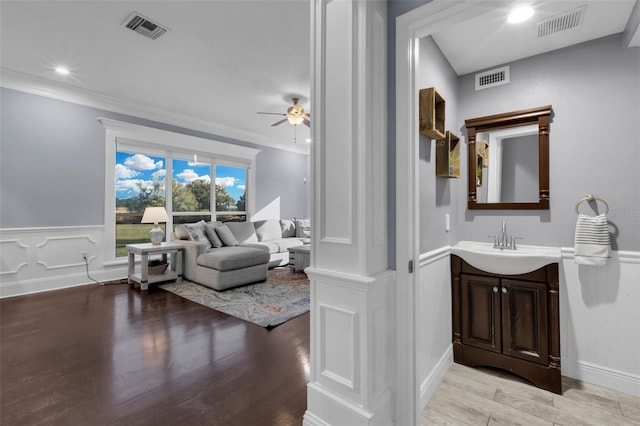 bathroom with vanity, hardwood / wood-style floors, crown molding, and ceiling fan